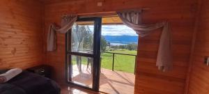 Zimmer mit einem Fenster und Blick auf einen Balkon. in der Unterkunft Hospedaje cabaña Guatavita finca las acacias in Guatavita