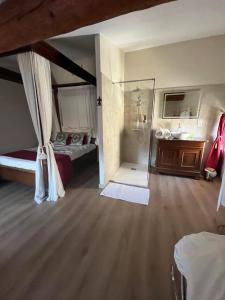 a bedroom with a bed and a glass shower at La Halte Louis XIII in Bram