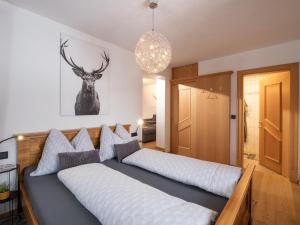 een slaapkamer met 2 bedden en een hertenfoto aan de muur bij Appartement Penningdörfl in Hopfgarten im Brixental
