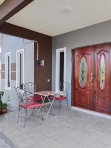 uma mesa e cadeiras em frente a uma porta de madeira em Villa Adeeva Homestay Langkawi em Pantai Cenang