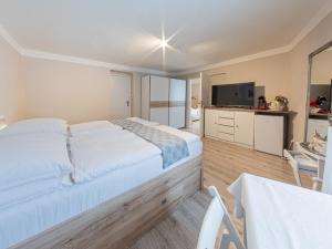 Un dormitorio con una gran cama blanca y una mesa en Frauenberg en Banská Štiavnica