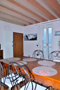 a dining room with a wooden table and chairs at White Garden - Apartment with access to the Lake in Lierna