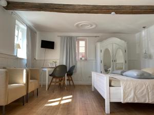 Schlafzimmer mit einem Bett, einem Schreibtisch und einem Stuhl in der Unterkunft Sonnenhof 1737 - Ferienzimmer & Apartments in Barbelroth