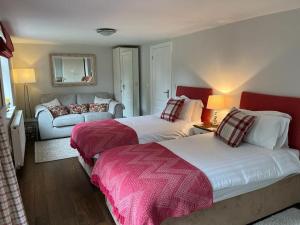Habitación de hotel con 2 camas y sofá en The Chestnuts en Glastonbury