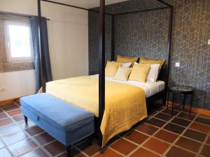 - une chambre avec un lit à baldaquin et un tabouret bleu dans l'établissement Quinta de Moçamedes - Turismo de Habitação, à Vouzela