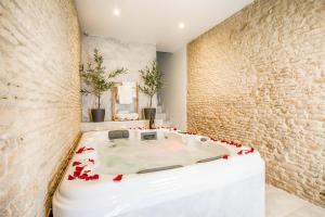 una habitación con una mesa blanca con rosas. en Single House with Jacuzzi and Sauna in Normandy en Ranville