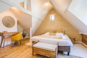 a bedroom with a bed and a desk in a attic at Single House with Jacuzzi and Sauna in Normandy in Ranville