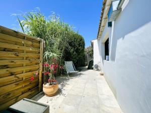 a garden with a wooden fence and flowers in a pot at Villa Rose in Rivedoux-Plage