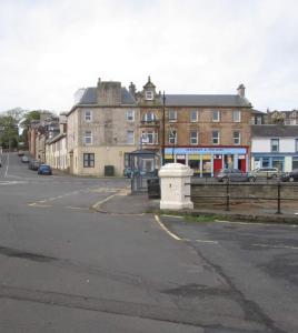 an empty street with buildings and a bus stop at Wee Harbour View in Millport