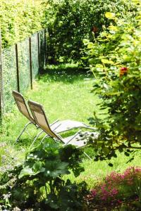 une chaise assise dans l'herbe du jardin dans l'établissement La Casa Royal Town house & Castle, à Falaise