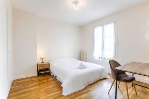 - une chambre blanche avec un lit et une table dans l'établissement La Casa Royal Town house & Castle, à Falaise