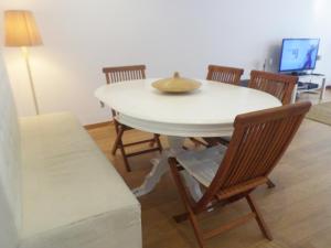 a white table with chairs and a hat on top at 33 José Farinha in Lisbon