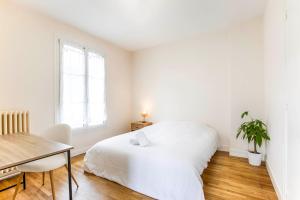 - une chambre blanche avec un lit et une table dans l'établissement La Casa Royal Town house & Castle, à Falaise