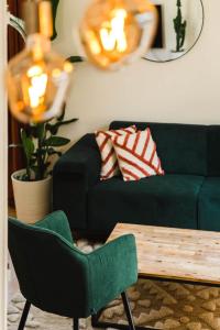 - un salon avec un canapé et un fauteuil vert dans l'établissement La Casa Royal Town house & Castle, à Falaise