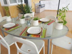 una mesa de cristal con placas blancas y plantas en ella en 33 José Farinha, en Lisboa