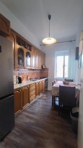 a kitchen with wooden cabinets and a table in it at Lukas Apartament Vollga Durres in Durrës