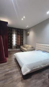 a bedroom with a large bed and a couch at Lukas Apartament Vollga Durres in Durrës