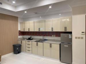 a kitchen with white cabinets and stainless steel appliances at بولاريس للشقق المخدومه in Ar Ruʼays