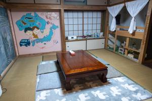 una habitación con una mesa y un mapa en la pared en Dear Uうわじまゲストハウス＆カフェ, en Uwajima