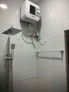 a shower stall with a soap dispenser on a wall at Blueocean.cog in Benin City