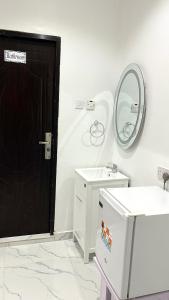 La salle de bains est pourvue d'une porte noire et d'un miroir. dans l'établissement Blueocean.cog, à Benin City