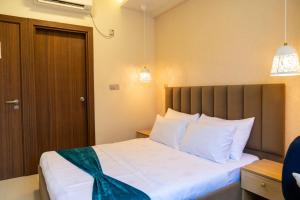 1 dormitorio con 1 cama grande con almohadas blancas en Moodhukoe en Malé