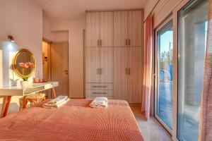 1 dormitorio con cama, mesa y espejo en Magedico 150m from the beach en Kissamos