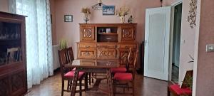 a dining room with a wooden table and chairs at Le Genest St Isles in Le Genest