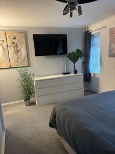 a bedroom with a bed and a tv on the wall at Clarke's AirBnB in Worthing