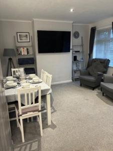 a living room with a table and chairs and a television at Clarke's AirBnB in Worthing