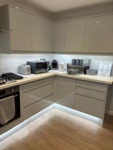 a kitchen with white cabinets and white appliances at Clarke's AirBnB in Worthing