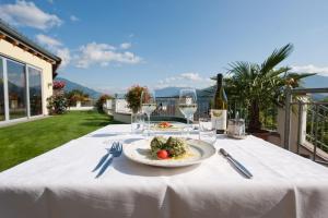 una mesa con un plato de comida y copas de vino en Hotel Haus an der Luck, en Barbiano