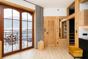 um quarto com uma grande porta de vidro e uma varanda em White Sheep by LoftAffair em Kościelisko
