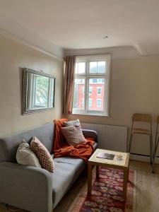 a living room with a couch and a table at Cozy Two Bedroom Apartment in London