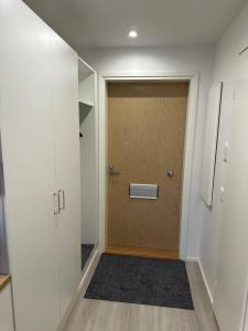 korytarz z drewnianymi drzwiami w pokoju w obiekcie Tyylikäs studio rauhallisella sijainnilla w mieście Rovaniemi