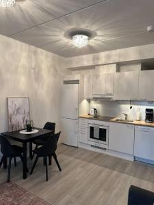 una cucina con tavolo e frigorifero bianco di Tyylikäs studio rauhallisella sijainnilla a Rovaniemi