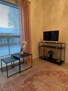 羅瓦涅米的住宿－Tyylikäs studio rauhallisella sijainnilla，客厅配有平面电视和桌子。