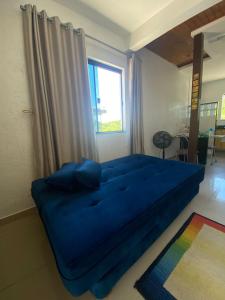 Cama grande azul en habitación con ventana en Casa Aconchegante, en Florianópolis