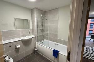 a bathroom with a tub and a sink and a shower at Cosy 1 Bed Central Manchester Apartment Sleeps 2 in Manchester