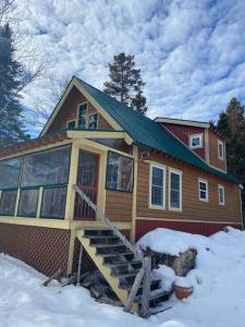 ein Haus im Schnee mit einer Veranda in der Unterkunft The Cedar Hutch in Cedarville