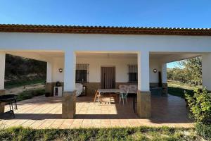 un patio con mesa y sillas. en Casa rural de encanto en plena Serranía de Ronda, en Ronda