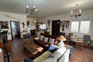 sala de estar con sofá y mesa en Casa rural de encanto en plena Serranía de Ronda, en Ronda