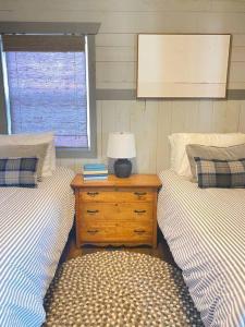 ein Schlafzimmer mit 2 Betten und einem Tisch mit einer Lampe in der Unterkunft The Cedar Hutch in Cedarville