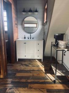 ein Badezimmer mit einem weißen Waschbecken und einem Spiegel in der Unterkunft The Cedar Hutch in Cedarville