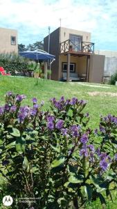 un arbusto con flores púrpuras delante de una casa en Cabaña La Tamarita barrio colinas verdes Sierra de los Padres en Mar del Plata