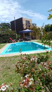 una piscina con una casa en el fondo en Cabaña La Tamarita barrio colinas verdes Sierra de los Padres en Mar del Plata