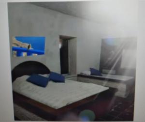 sypialnia z łóżkiem z niebieskimi poduszkami w obiekcie Τraditional seaside room HOMER w mieście Artemida