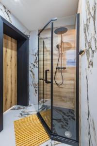 een douche met een glazen deur in een kamer bij Willa na Skarpie in Kościelisko