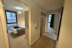 1 dormitorio con cama y pasillo con espejo en Airy 1 Bed Central Manchester Apartment Sleeps 2, en Mánchester