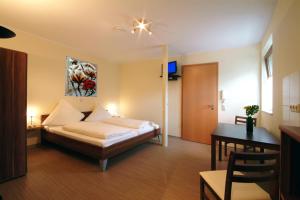 a hotel room with a bed and a table and a desk at Landgasthof Lang Zum Adler in Oberkalbach